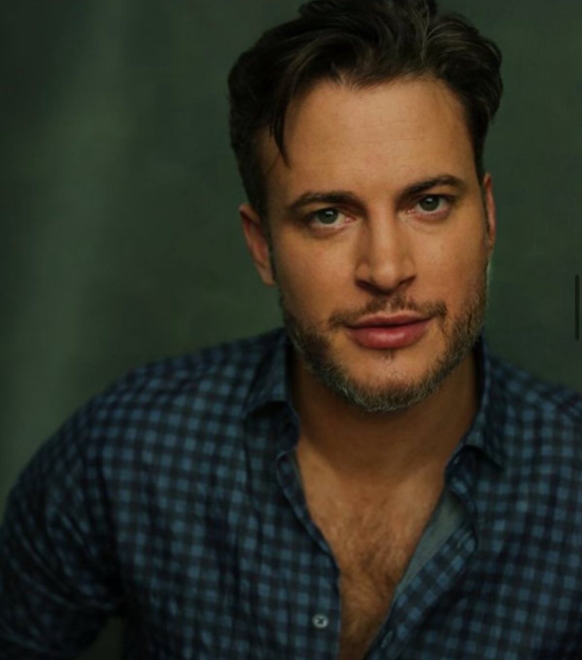 Gary Lucy, British actor, headshot in a blue checked shirt