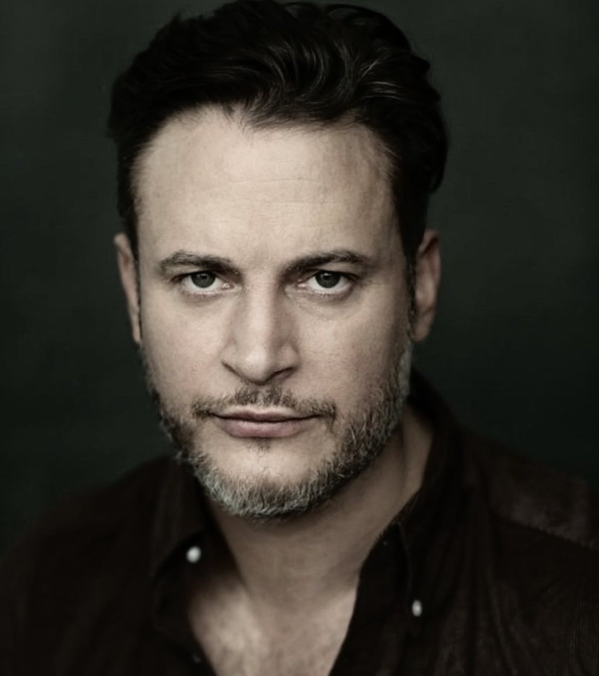 Gary Lucy, British actor, headshot against a dark background